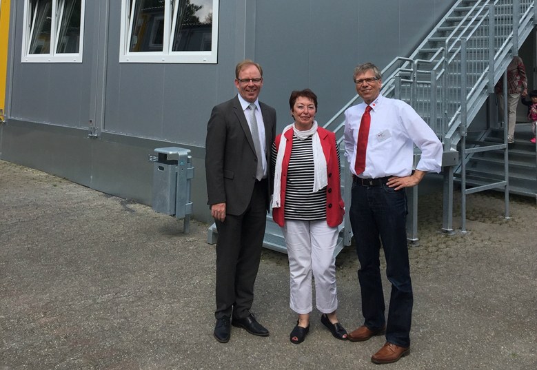 Sozialamtsleiter Jürgen Hages, Angelika Quiring-Perl, Stadtverordnete für Reuschenberg, und Marc Dietrich, Leiter des DRK Neuss vor den Wohncontainern am Südpark.