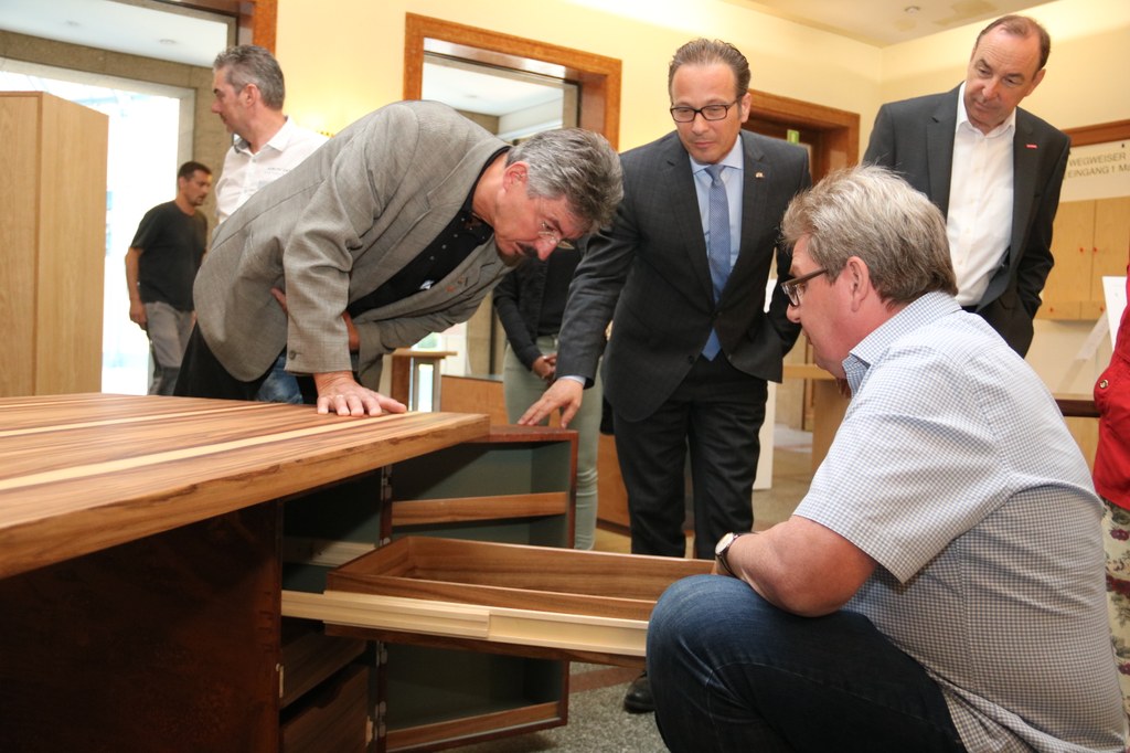 Lassen sich die Ausstellungstücke zeigen: Bürgermeister Reiner Breuer (m.), Uwe Köhler (l.), Obermeister der Tischler-Innung im Rhein-Kreis Neuss, und Klaus Kordewski (r.), stellvertretender Hauptgeschäftsführer der Kreishandwerkerschaft Niederrhein.