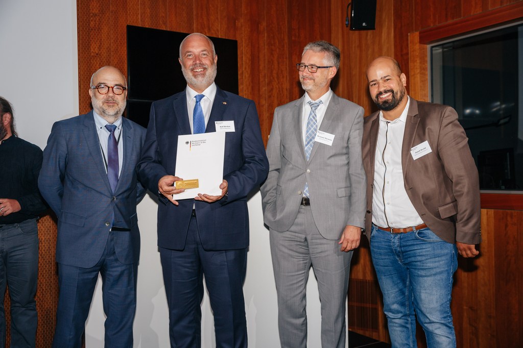 Staatssekretär Dr. Markus Kerber übergab die Urkunde und die vergoldete Türklingel an Integrationsdezernent Ralf Hörsken, Hermann Murmann, Leiter des Integrationsamtes, und Hamdi Berdid vom Raum der Kulturen Neuss e.V. (v.l.).