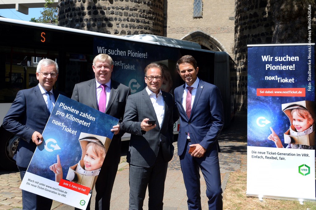 Stadtwerke Neuss-Geschäftsführer Stephan Lommetz, der Neusser nextTicket-Tester Rainer Weidenfeld, Bürgermeister Reiner Breuer und VRR-Vorstand Luis Castrillo am Neusser Obertor (v.l.n.r.).   Foto: Stadtwerke Neuss/Andreas Woitschützke