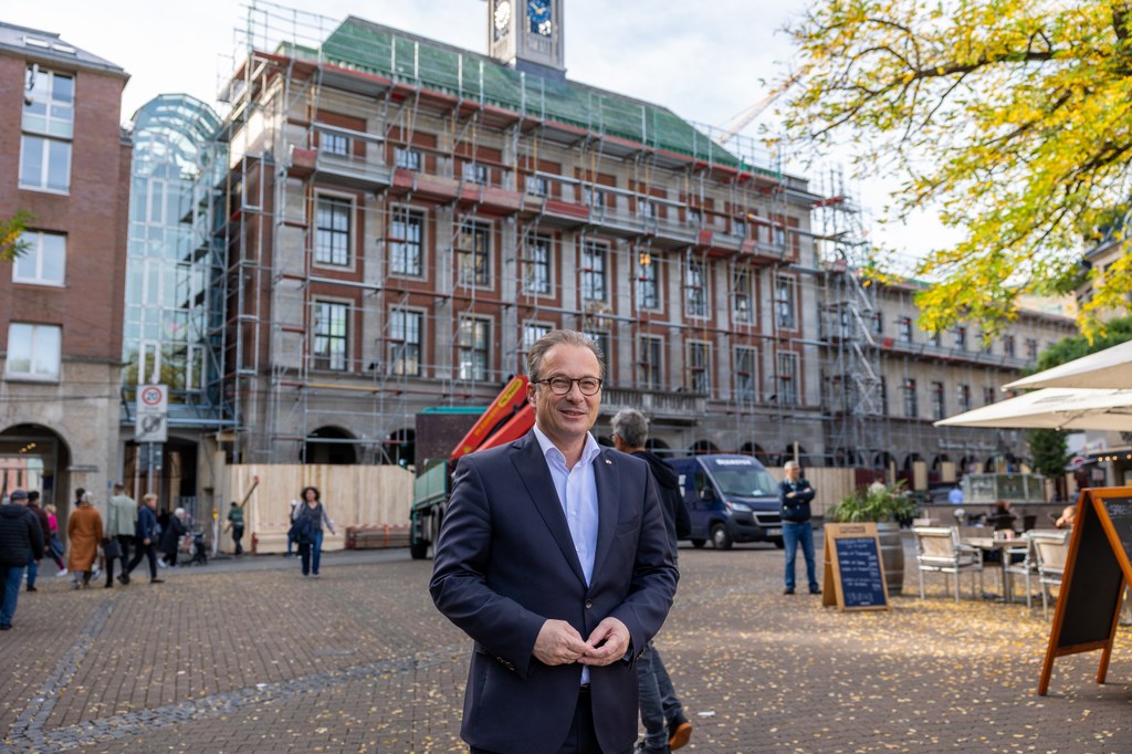 Bürgermeister Breuer vor dem eingerüsteten Rathaus
