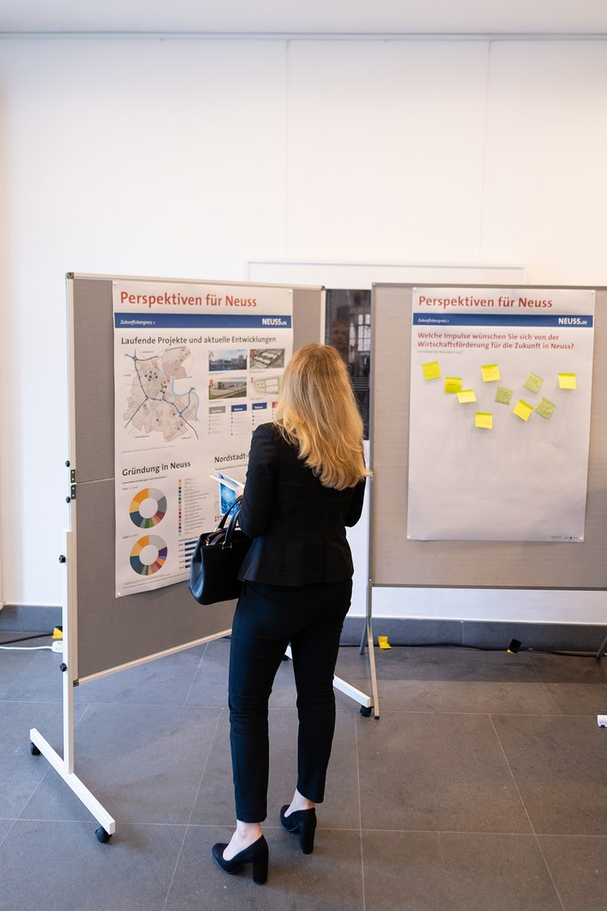neusser-zukunftskongress-2022_02b.jpg Eine Frau informiert sich an zwei Aufstellwänden.